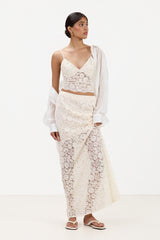 Front view of cream lace bra top paired with matching lace maxi skirt and a shirt